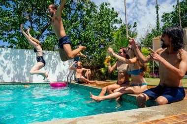 Havuzda yüzme havuzu partisinde eğlenen çok ırklı genç arkadaş grubu salgının yayılması havadayken