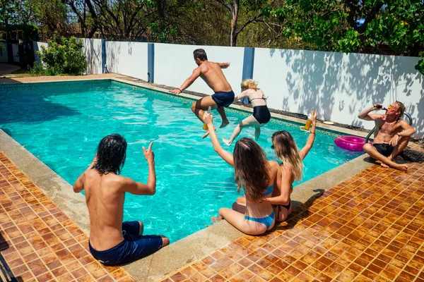 Groupe de heureux six amis boire sauter dans la piscine fête de jour avec éclaboussure — Photo