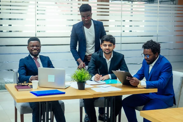 Grupp av företag internationella människor tittar på diagrammet på blädderblock i moderna ekokontor — Stockfoto