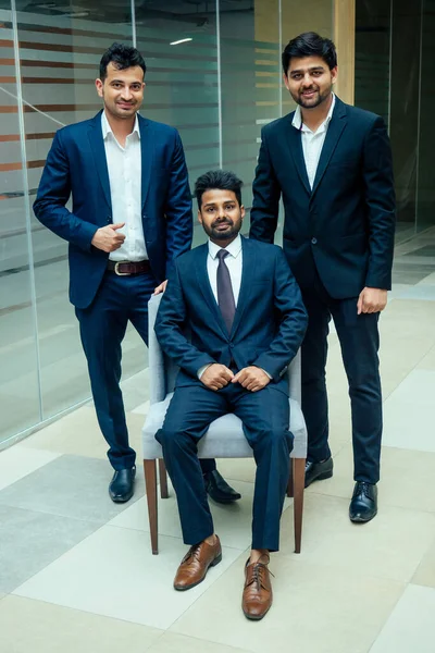 well-dressed business indian men making a report to subordinate employees in a modern office