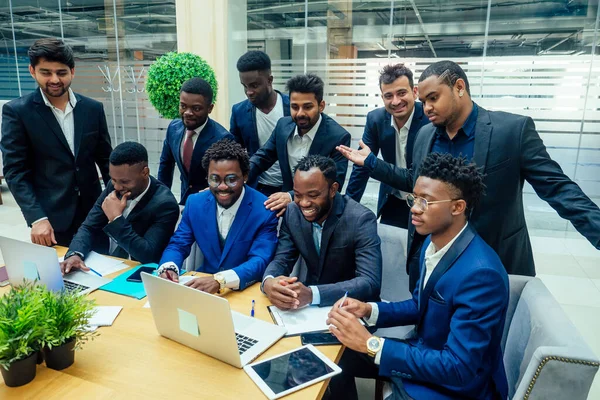 Grupo de gente internacional de negocios mirando el gráfico en el rotafolio en la oficina ecológica moderna —  Fotos de Stock