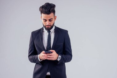 İtalyan genç başarılı yakışıklı siyah saçlı şık takım elbiseli adam stüdyoda beyaz arkaplanı izole ediyor.