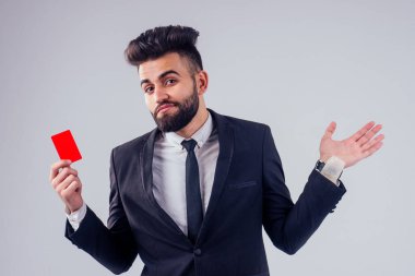 Stüdyoda şık takım elbiseli genç siyah saçlı adam beyaz arkaplanı izole ediyor.