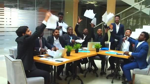 Международная группа из десяти взволнованных молодых бизнесменов, выбрасывающих газеты и пожимающие руки — стоковое видео