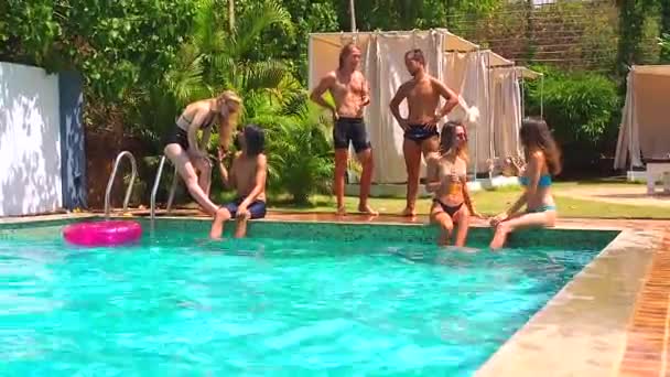 Groupe de six jeunes gens qui s'amusent, parlant près de la piscine, journée chaude — Video