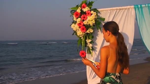 Dekorateur arbeitet mit Blumen-Komposition für Hochzeitsbogen am Strand — Stockvideo