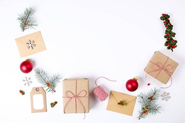  Noel çerçeve kompozisyon. Noel hediyesi, çam dalı, kırmızı topları, zarf, Beyaz ahşap kar taneleri, şerit ve kırmızı meyveler. Üstten Görünüm, düz yatıyordu, kopya alanı.