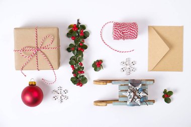 Noel mutlu yeni yıl kompozisyon. Noel hediyeleri, çam dalı, kırmızı topları, zarf, Beyaz ahşap kar taneleri, şerit, kırmızı meyveler ve mevcut etiketleri. Üstten Görünüm, düz yatıyordu, kopya alanı.