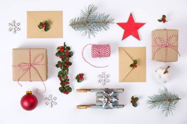 Noel mutlu yeni yıl kompozisyon. Noel hediyeleri, çam dalı, kırmızı topları, zarf, Beyaz ahşap kar taneleri, şerit, kırmızı meyveler ve mevcut etiketleri. Üstten Görünüm, düz yatıyordu, kopya alanı.