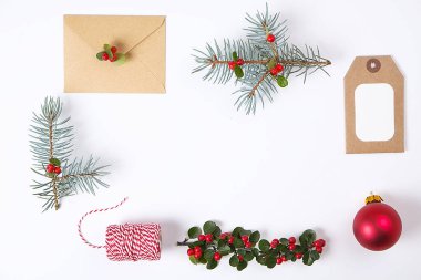 Noel çerçeve kompozisyon. Çam dalı, kırmızı topları, zarf, Beyaz ahşap kar taneleri, şerit ve kırmızı meyveler. Üstten Görünüm, düz yatıyordu, kopya alanı.