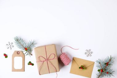 Noel çerçeve kompozisyon. Noel hediyesi, çam dalı, kırmızı topları, zarf, Beyaz ahşap kar taneleri, şerit ve kırmızı meyveler. Üstten Görünüm, düz yatıyordu, kopya alanı.
