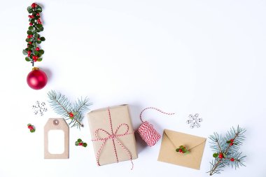Noel çerçeve kompozisyon. Noel hediyesi, çam dalı, kırmızı topları, zarf, Beyaz ahşap kar taneleri, şerit ve kırmızı meyveler. Üstten Görünüm, düz yatıyordu, kopya alanı.