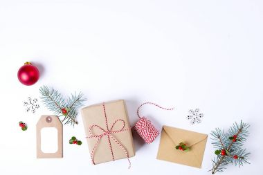 Noel çerçeve kompozisyon. Noel hediyesi, çam dalı, kırmızı topları, zarf, Beyaz ahşap kar taneleri, şerit ve kırmızı meyveler. Üstten Görünüm, düz yatıyordu, kopya alanı.