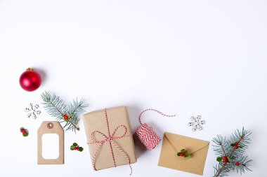 Noel çerçeve kompozisyon. Noel hediyesi, çam dalı, kırmızı topları, zarf, Beyaz ahşap kar taneleri, şerit ve kırmızı meyveler. Üstten Görünüm, düz yatıyordu, kopya alanı.