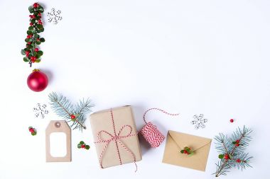 Noel çerçeve kompozisyon. Noel hediyesi, çam dalı, kırmızı topları, zarf, Beyaz ahşap kar taneleri, şerit ve kırmızı meyveler. Üstten Görünüm, düz yatıyordu, kopya alanı.