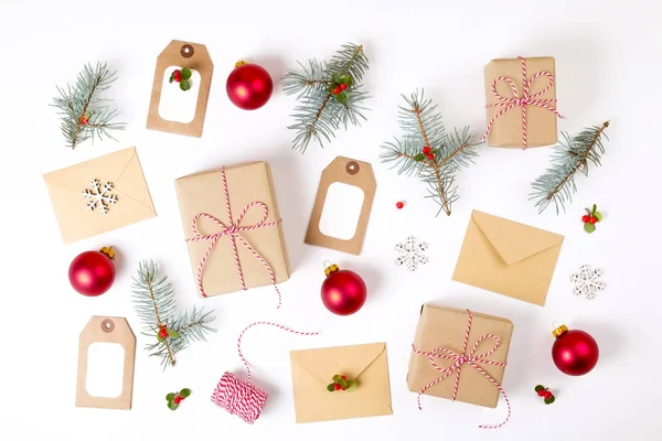 Noel mutlu yeni yıl kompozisyon. Noel hediyeleri, çam dalı, kırmızı topları, zarf, Beyaz ahşap kar taneleri, şerit, kırmızı meyveler ve mevcut etiketleri. Üstten Görünüm, düz yatıyordu, kopya alanı.