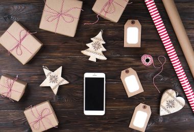 Noel ile akıllı telefon üzerinde ahşap arka plan üstten görünüm sunar. Online tatil alışveriş kavramı. Düz lay, metin alanı. Internet ticaret kış tatil kavramı.