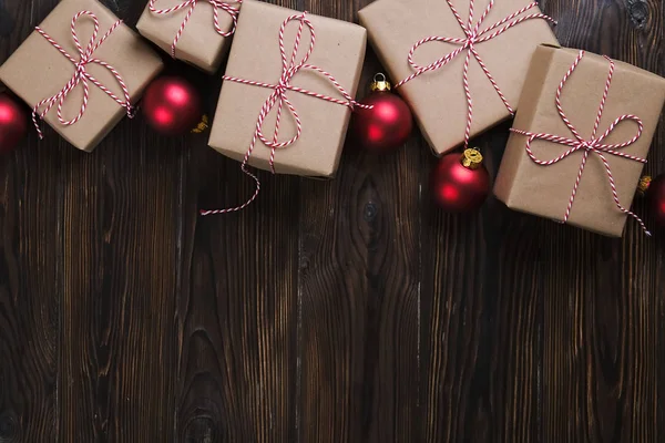 Weihnachtsgeschenke Box Geschenke mit roten Kugeln auf hölzernem Hintergrund von oben Ansicht Text Raum — Stockfoto