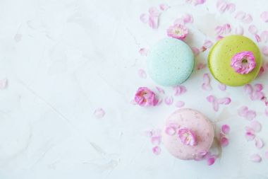 Macaron veya acıbadem kurabiyesi Fransız coockie beyaz dokulu arka plan bahar ile lila çiçekler, pastel renkler. 