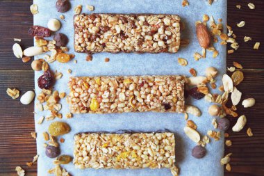 Kuru meyve, fındık, granola ve ahşap zemin üzerine süt ile tahıl barlar. Üstten Görünüm. Sağlıklı ev yapımı Mısır gevreği barlar ile fındık, tohumlar ve kuruyemiş ahşap tablo.