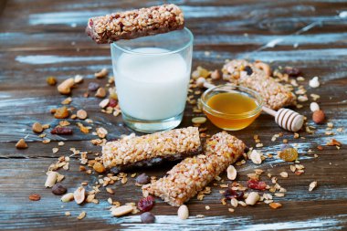 Kuru meyve, fındık, granola ve ahşap zemin üzerine süt ile tahıl barlar. Üstten Görünüm. Sağlıklı ev yapımı Mısır gevreği barlar ile fındık, tohumlar ve kuruyemiş ahşap tablo.