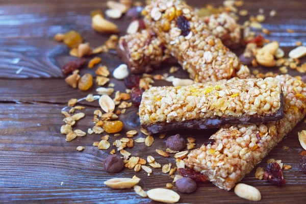 Cereal bars with dry fruits, nuts, granola and glass of milk on wooden background.Top view.Healthy homemade cereal bars with nuts, seeds and dried fruits on the wooden table.