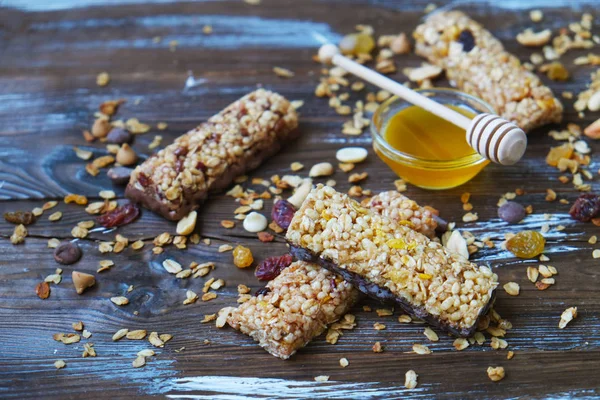 Barras de granola saludables en la mesa de madera.Variedad de barras de cereales con nueces, semillas, frutas secas y chocolate en la mesa de madera, vista superior . — Foto de Stock