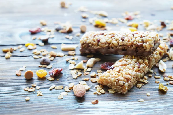 Barras de granola saludables en la mesa de madera.Variedad de barras de cereales con nueces, semillas, frutas secas y chocolate en la mesa de madera, vista superior . — Foto de Stock