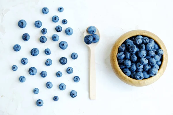 Świeżo zebranych jagody na biały, łyżka z jagód i miska z blueberry. Leżał z płaskim. — Zdjęcie stockowe