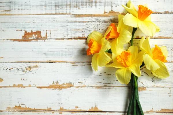 Frische frühlingshafte gelbe Narzissen, Tulpenblüten auf grün bemalten Holzplanken. Platz für Text. — Stockfoto