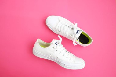 Kadınsı aksesuarları düz yatıyordu. Kadın Ayakkabı, çanta, smartphone ve pembe bir arka plan nöbette. Bej renk kadın aksesuarları. Metin alanı. Üstten Görünüm. Beyaz, pembe arka plan snickers.