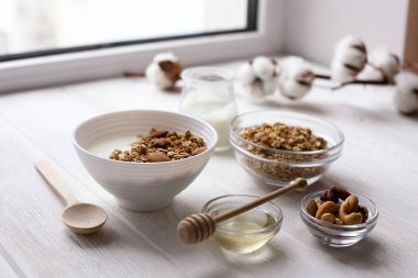 Ev yapımı granola veya Beyaz ahşap zemin üzerine Yoğurtlu müsli