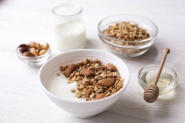Ev yapımı granola veya Beyaz ahşap zemin üzerine Yoğurtlu müsli