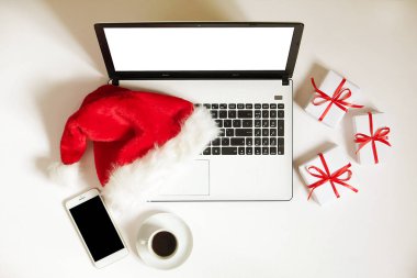 Kahve, laptop, Noel hediyesi ile iş yerinde ve santa şapka beyaz zemin üstüne kopya alanı ile görüntüleyin. İş Noel tatil kavramı, tatil online alışveriş kavramı