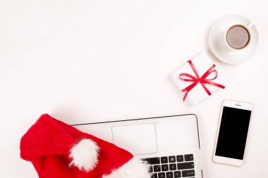 Kahve, laptop, Noel hediyesi ile iş yerinde ve santa şapka beyaz zemin üstüne kopya alanı ile görüntüleyin. İş Noel tatil kavramı, tatil online alışveriş kavramı