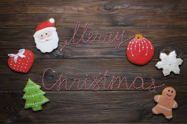 Noel gingerbread çerezleri neşeli Noel şerit metin ve çam dalı koyu ahşap arka plan ile. Noel arka plan kompozisyon