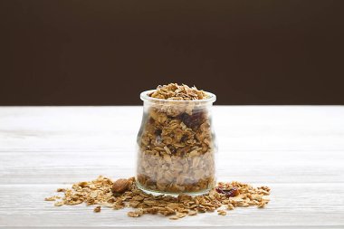 Mix fındık, Kuru Meyve, Kuru üzüm, çikolata, yulaf spikelets, bal ve Beyaz ahşap masa üzerinde granola tahıl superfood enerji çubuklarıyla