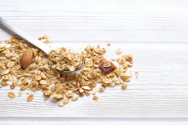 Mix fındık, Kuru Meyve, Kuru üzüm, çikolata, yulaf spikelets, bal ve Beyaz ahşap masa üzerinde granola tahıl superfood enerji çubuklarıyla