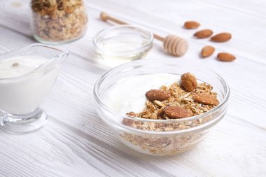 Sağlıklı ev yapımı granola veya Beyaz ahşap zemin üzerine Yoğurtlu müsli
