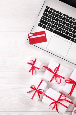 Ofis büro dizüstü bilgisayar ile Noel hediyeleri ve kredi kartı ONLAIN sipariş düz beyaz arka plan üzerinde kopya alanı ile yatıyordu. İş Noel tatil kavramı, tatil online alışveriş kavramı