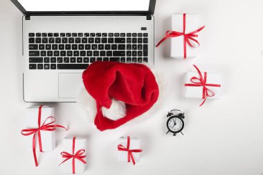 Ofis büro dizüstü bilgisayar ile Noel hediyeleri ve beyaz arka plan düz gündeminde kopya alanı ile yatıyordu. İş Noel tatil kavramı, tatil online alışveriş kavramı