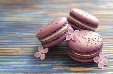   Bilberry macaroons. Mor macaroons. Kavram acıbadem kurabiyesi arka plan. Mavi koyu ahşap bankamatik üzerinde mor macaroons.