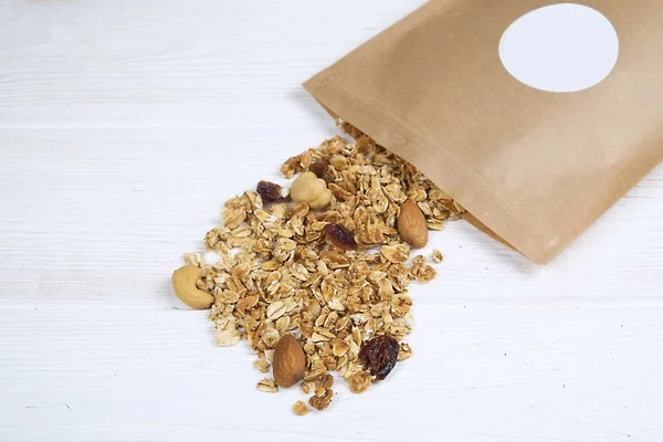 Mixed nuts, dry fruits muesli, cashew, almond, hazelnut, raisins, cranberry on white wooden table. Healthy nutritious vegan fitness dietary super food pack. Flat lay, top view, copy space, background.