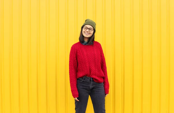 Millenial chica im ropa de moda pasar un buen rato, haciendo caras divertidas cerca de brillante amarillo pared urbana . — Foto de Stock