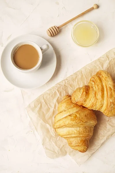 Köstliche Kaffee-Tasse am Morgen mit Croissant in Nahaufnahme auf weiß — Stockfoto