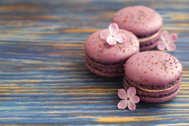 Fransız yaban mersini macarons buiscits whith çiçek ahşap arka plan üzerinde