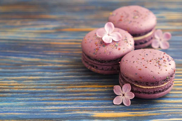 French blueberry macarons buiscits whith flowers on wooden background — Stock Photo, Image