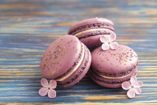 Macarrones de arándanos franceses buiscits con flores sobre fondo de madera — Foto de Stock