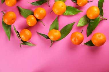 Mandarin portakal sağlam pembe tablo arka plan üzerinde.
