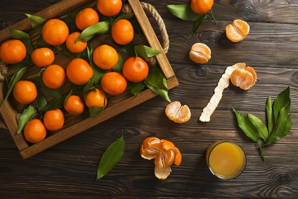 Φρέσκα πορτοκάλια μανταρίνι σε ένα ξύλινο τραπέζι. Φλούδα μανταρινιού. Μισά, φέτες και ολόκληρο closeup κλημεντίνες. — Φωτογραφία Αρχείου